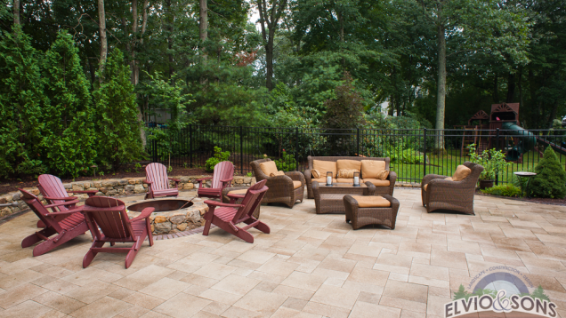Seating area by built-in fireplace on Unilock patio.