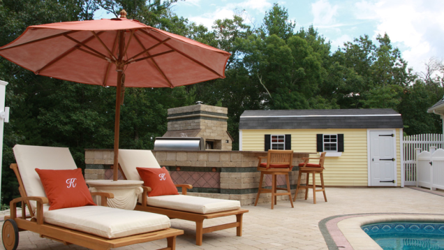 Lounge by the in-ground pool on patio seating.