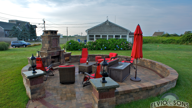 Circular paver patio, built-in fireplace, and block seating walls.