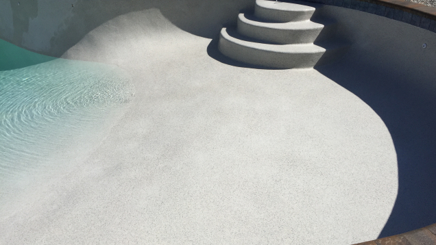 In-ground gunite pool restoration complete. Plaster and pebble finish applied. Pool filling in progress.