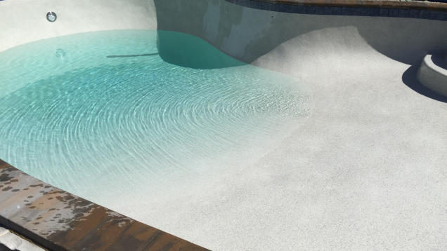 In-ground gunite pool restoration complete. Plaster and pebble finish applied. Pool filling in progress.