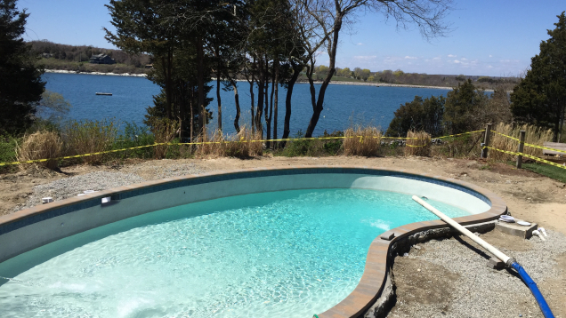 In-ground gunite pool restoration complete. Plaster and pebble finish applied. Pool filling in progress.