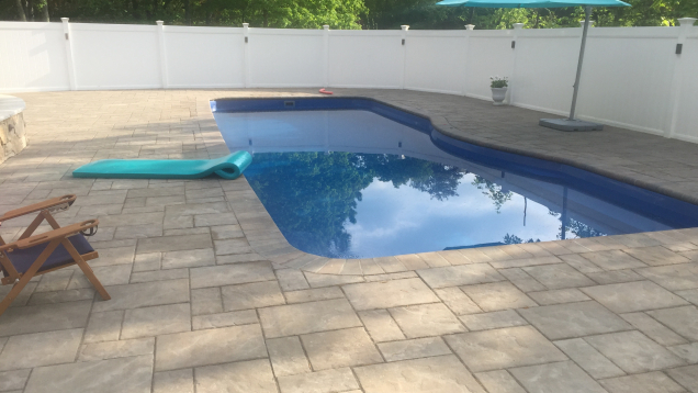 In-ground pool and Unilock patio in Medway, MA.