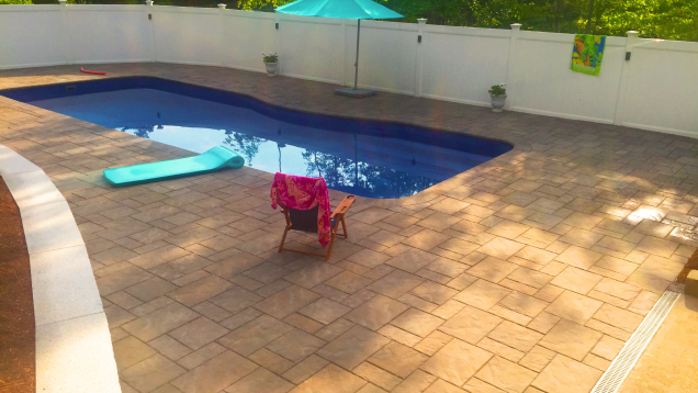 In-ground pool and Unilock patio in Medway, MA.