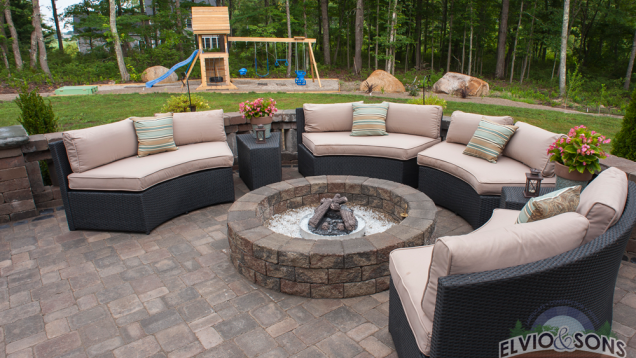 Seating area on paver patio with built-in fire place.