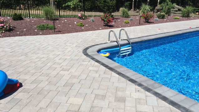 Unilock paver patio installation in Johnston, RI with pool coping.