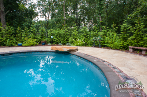 A pool with a "diving rock" (instead of a "diving board")